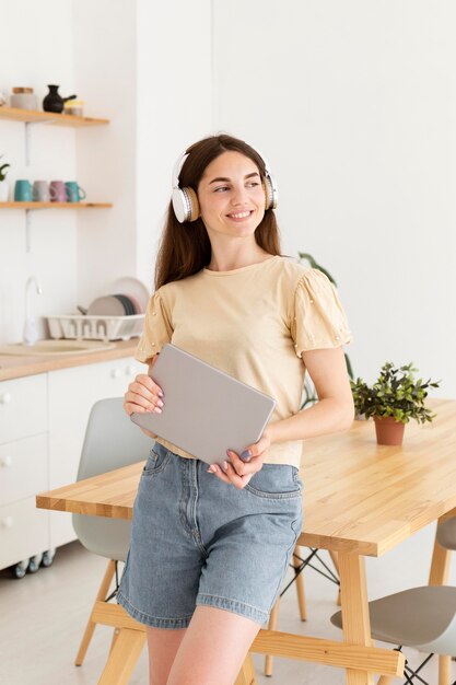 Mujer sonriente escuchando música en casa