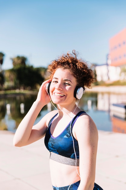 Mujer sonriente escuchando música durante el entrenamiento