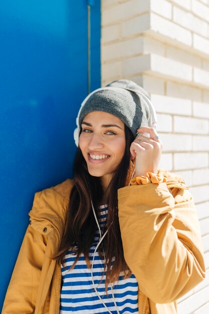 mujer sonriente escuchando música mirando a cámara