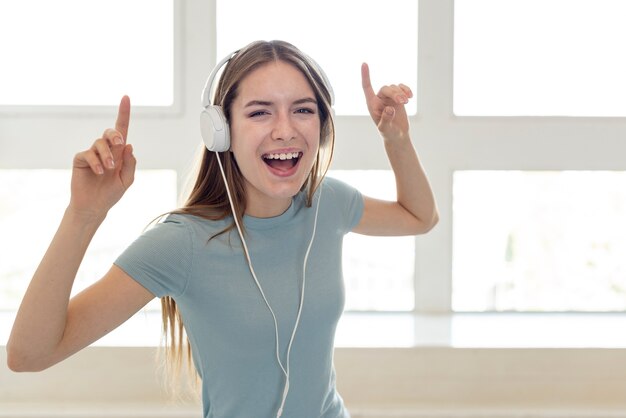 Mujer sonriente escuchando música a través de auriculares
