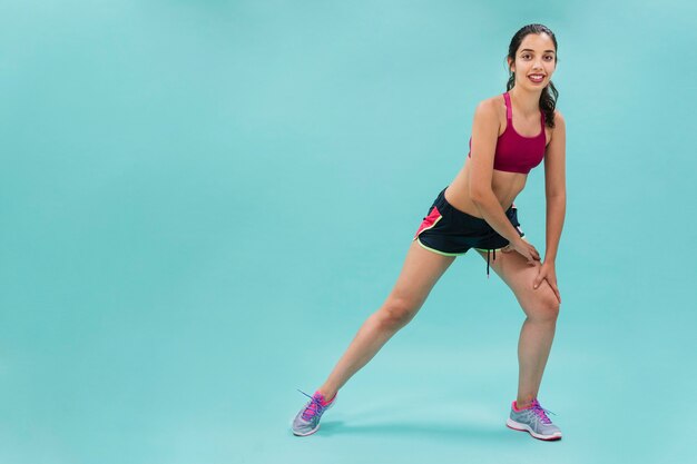 Mujer sonriente estirando y entrenando