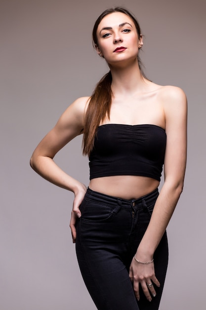 Mujer sonriente en estudio en blanco gris