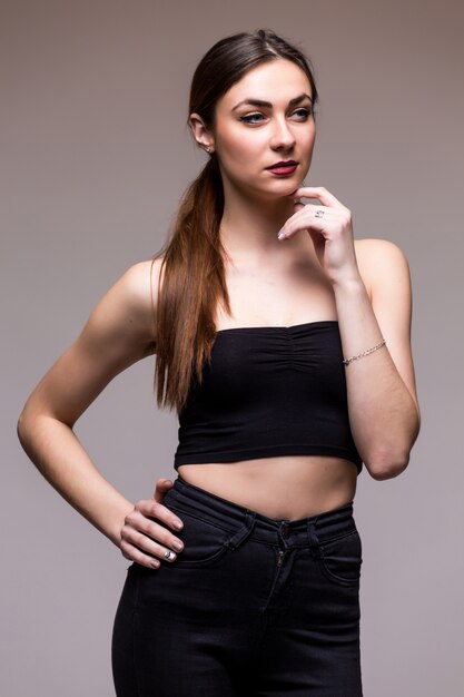 Mujer sonriente en estudio en blanco gris