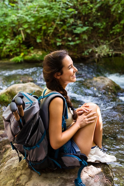 Mujer sonriente explorando la naturaleza con mochila