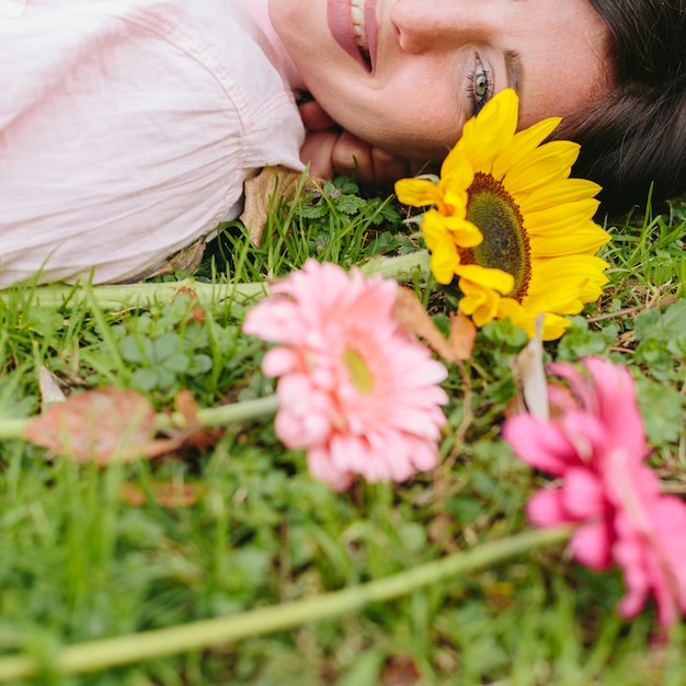 Mujer sonriente con flores en la hierba