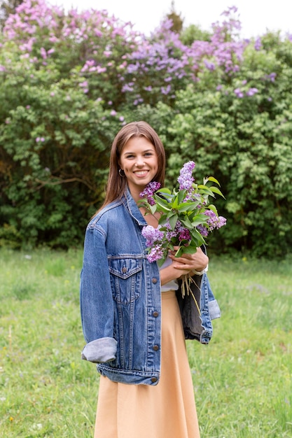 Mujer sonriente con flores lilas