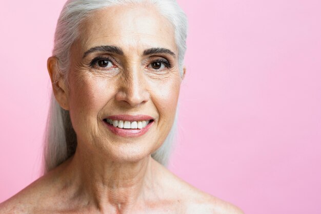 Mujer sonriente con fondo rosa