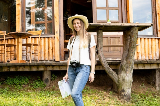 Foto gratuita mujer sonriente frente a una casa moderna