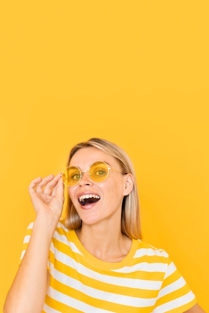 Mujer sonriente con gafas amarillas