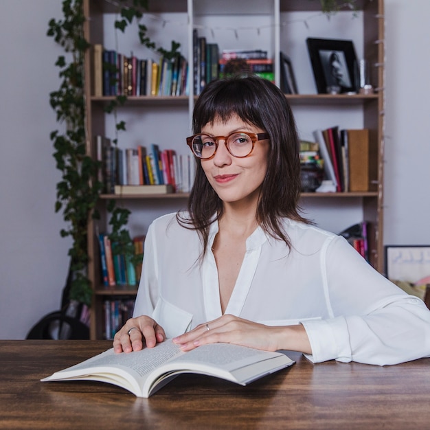 Foto gratuita mujer sonriente con gafas en escritorio