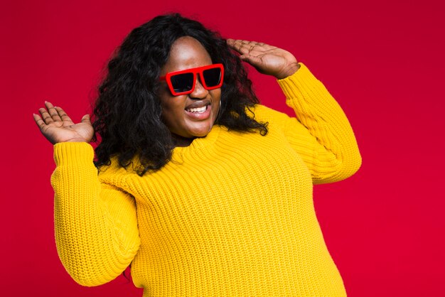 Mujer sonriente con gafas de sol bailando