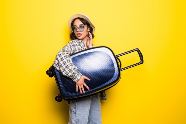 Mujer sonriente con gafas de sol y sombrero con maleta correr aislado