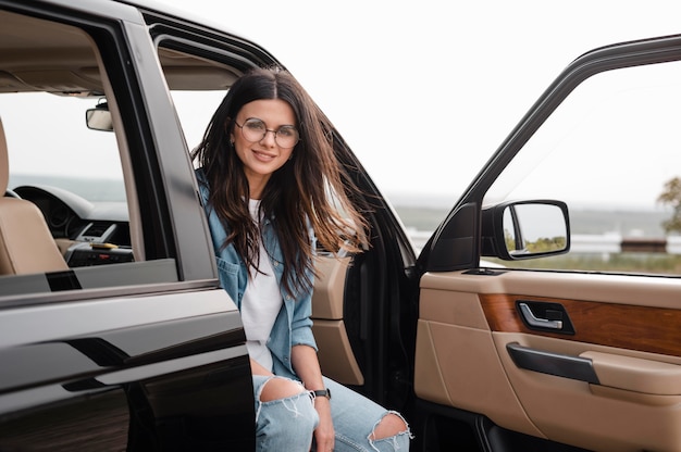 Foto gratuita mujer sonriente con gafas viajando sola en coche