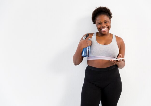 Mujer sonriente en el gimnasio con espacio de copia