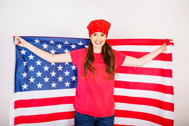 Mujer sonriente con gran bandera americana