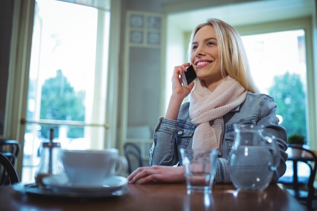 mujer sonriente hablando por teléfono móvil