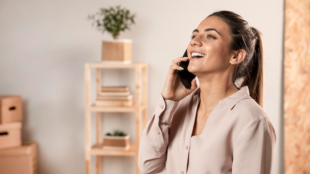 Foto gratuita mujer sonriente hablando por teléfono plano medio