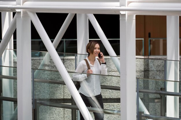 Mujer sonriente hablando por teléfono plano medio