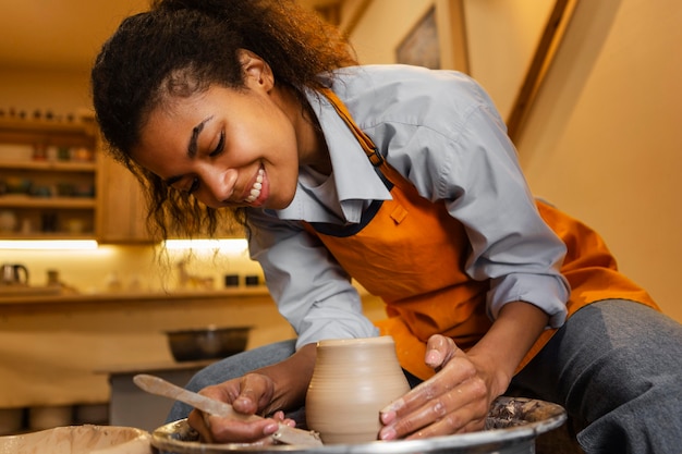 Mujer sonriente haciendo cerámica en interiores