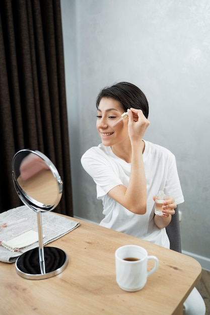 Foto gratuita mujer sonriente haciendo cuidado de la piel plano medio