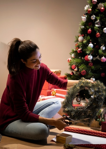 Mujer sonriente haciendo decoraciones para christams