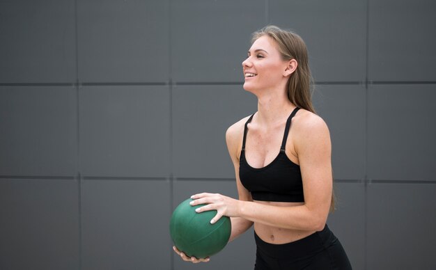 Mujer sonriente haciendo fitness con una pelota