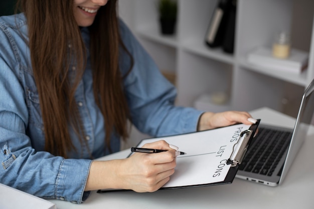 Mujer sonriente haciendo lista de pros y contras