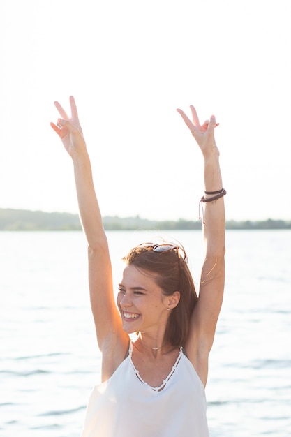 Mujer sonriente haciendo el signo de la paz