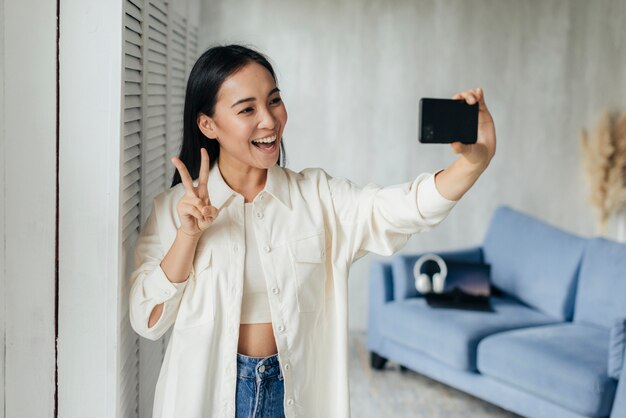 Mujer sonriente haciendo un vlog con su teléfono