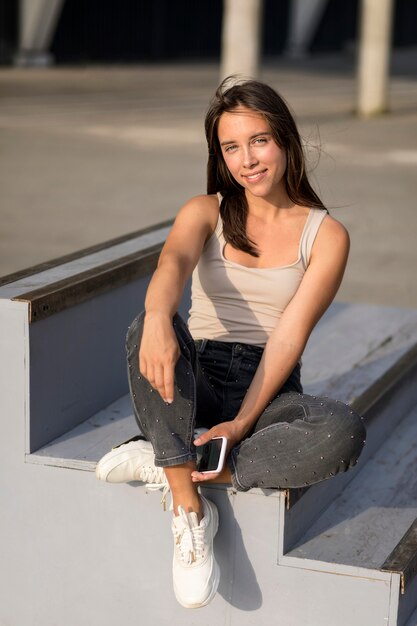 Mujer sonriente hermosa que presenta en las escaleras