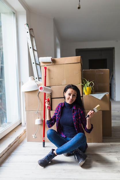 Mujer sonriente con herramientas de renovación