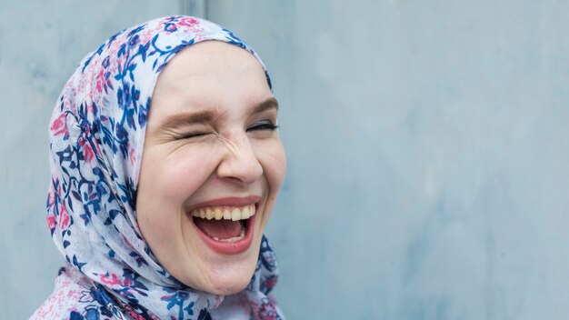 Foto gratuita mujer sonriente con hijab guiñando un ojo