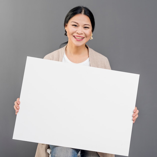 Mujer sonriente con hoja de papel en blanco