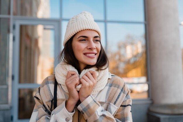 Mujer sonriente joven caminando en la calle en invierno