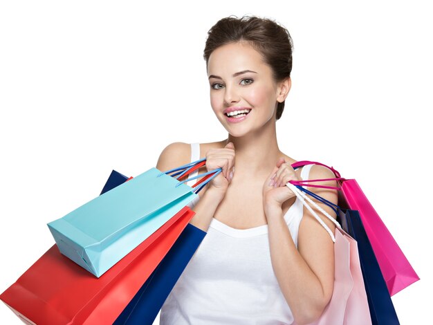 Mujer sonriente joven feliz con bolsas de la compra después de ir de compras