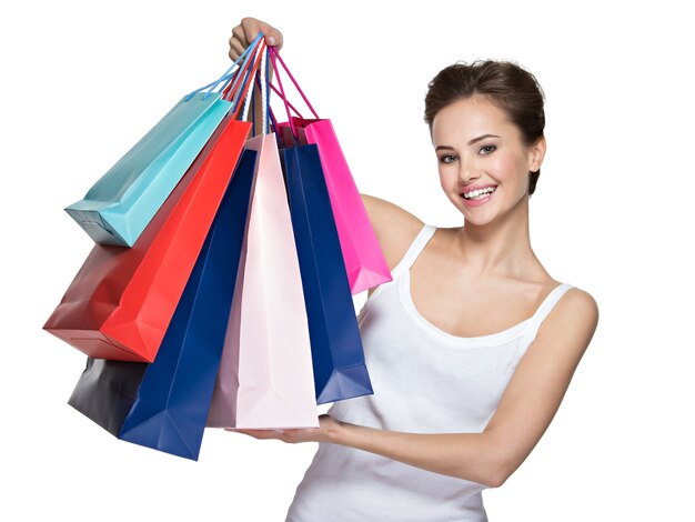 Mujer sonriente joven feliz con bolsas de la compra después de ir de compras