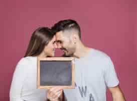 Foto gratuita mujer sonriente joven y hombre positivo que muestra el marco de la foto