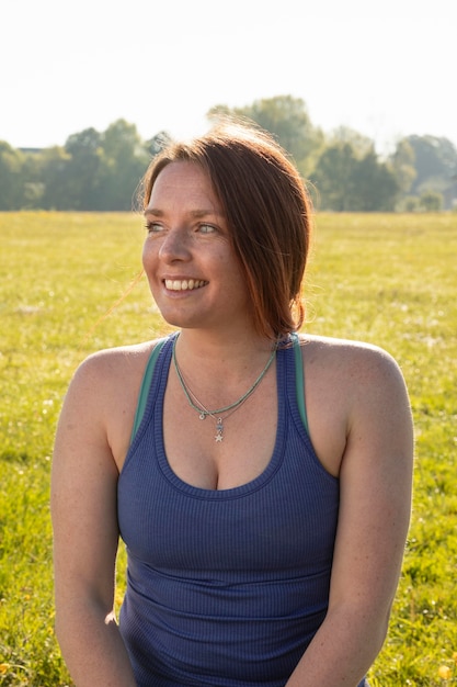 Mujer sonriente joven meditando al aire libre