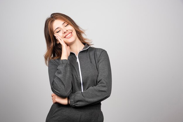 Mujer sonriente joven de pie y posando.