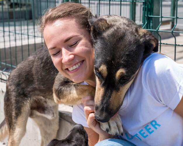 Mujer sonriente jugando con lindo perro en adopción