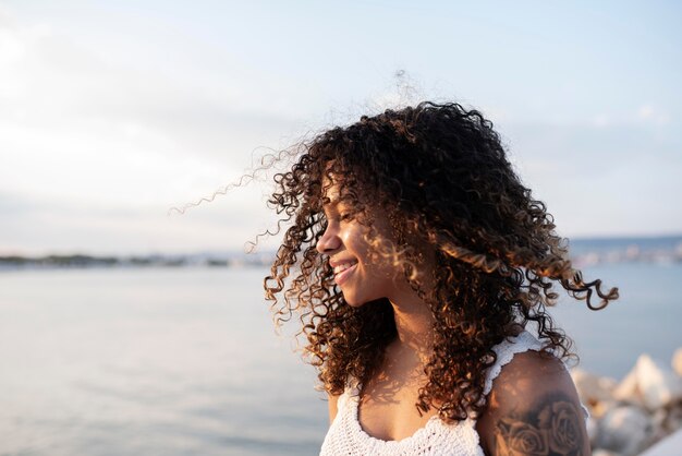 Mujer sonriente junto al mar de cerca