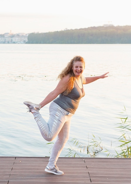 Mujer sonriente por el lago que se extiende