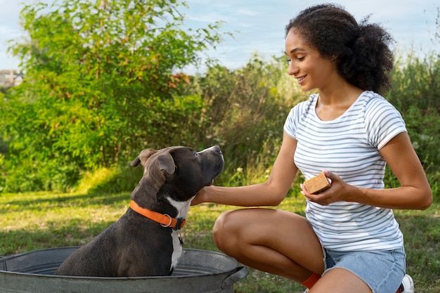 Foto gratuita mujer sonriente lavando perro vista lateral