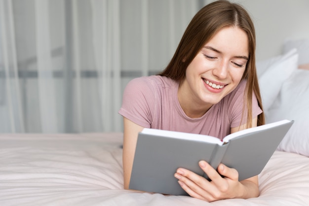 Mujer sonriente leyendo un libro interesante