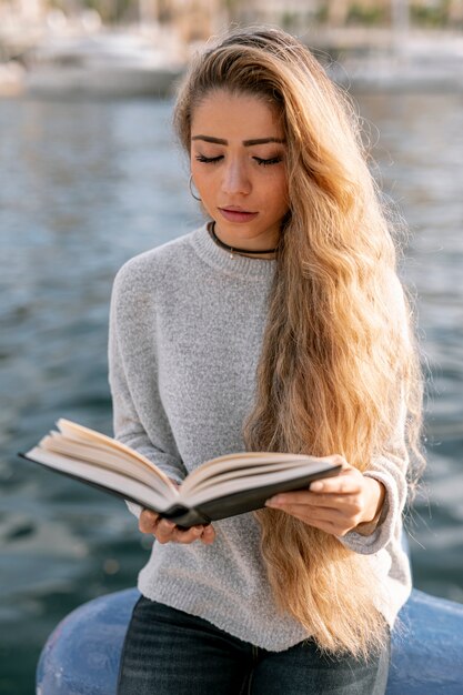 Foto gratuita mujer sonriente leyendo un libro