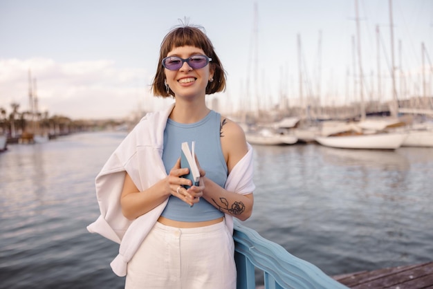 Mujer sonriente con libro mira a la cámara