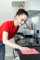 Foto gratuita mujer sonriente limpiando la cocina después de hornear en casa