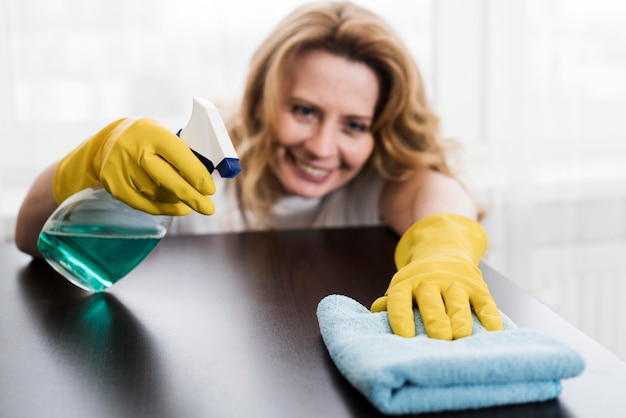 Mujer sonriente limpiando la mesa