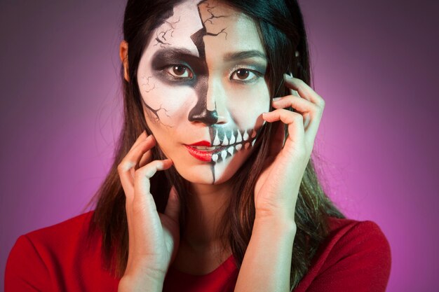 Mujer sonriente llevando máscara de halloween