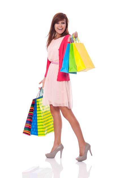 Mujer sonriente llevando muchas bolsas de la compra.